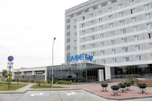 a large white building with a sign on it at East Time Hotel in Minsk