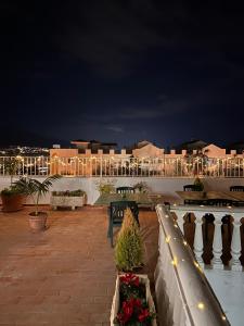 un patio nocturno con bancos y luces en Hostal San Felipe, en Marbella