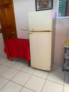 una nevera vieja en una cocina con una mesa roja en Casa Foranea, en Concepción