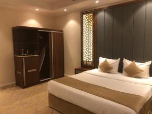 a bedroom with a large bed and a window at درة العروس للوحدات السكنية المفروشة in Jeddah