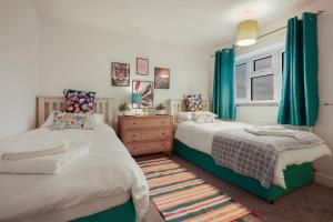 a bedroom with two beds and blue curtains at North Lincs Cosy Home in Messingham
