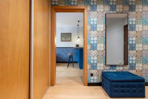 a hallway with a blue stool and a mirror at Homewell Apartments Czartoria- free parking in Poznań