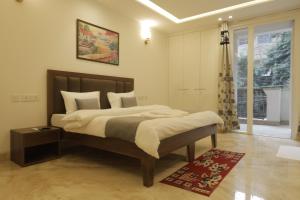 a bedroom with a large bed and a window at Under My Roof Superio in New Delhi