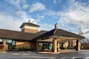 un edificio con una torre dell'orologio sopra di DoubleTree by Hilton Edinburgh Airport a Ingliston