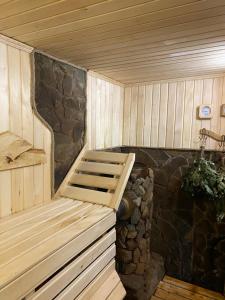 uma sauna com um banco numa parede de pedra em Guest house Shulc em Mizhhirʼʼya