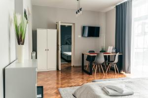 - une chambre avec un lit, une table et des chaises dans l'établissement Kamieniec No5 Apartments, à Zakopane
