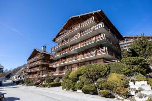 an apartment building with bushes in front of it at Les Busards 18 in Nendaz