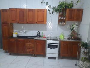 a kitchen with wooden cabinets and a stove top oven at Casa ampla e aconchegante in Florianópolis