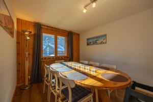 a dining room with a large wooden table and chairs at Les Busards 18 in Nendaz