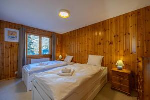 a bedroom with a large bed with wooden walls at Les Busards 18 in Nendaz