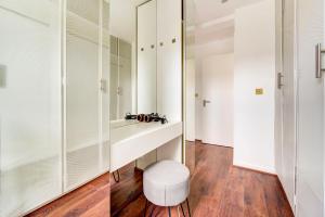 baño con armarios blancos y taburete blanco en 3 Bedroom Baker Street Central Apartments, en Londres
