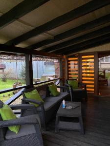 eine Veranda mit Stühlen, einem Sofa und einem Tisch in der Unterkunft Guest house Shulc in Mischhirja