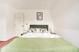 a bedroom with a large bed with a green blanket at 3 Bedroom Baker Street Central Apartments in London