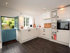 a kitchen with white cabinets and a window at 1 Bed in Rutland Waters 60672 in Oakham