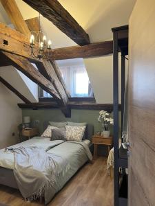 1 dormitorio con techo de madera y 1 cama con lámpara de araña en Mushrooms Malomszállás, en Tata