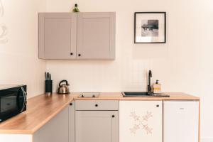 a kitchen with white cabinets and a counter top at Kamieniec No5 Apartments in Zakopane