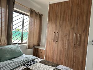 a bedroom with a large wooden cabinet next to a bed at F2 Farmhouse in Omuthiya