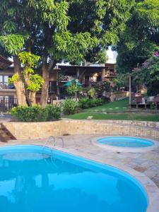 2 piscinas en un patio con una casa en Apartamentos em Ponta Negra (Natal-RN) com vista para o mar, en Natal