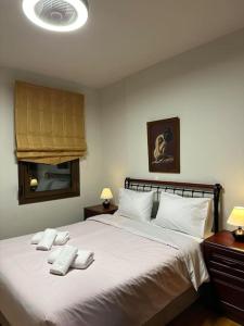 sypialnia z dużym łóżkiem z białą pościelą i poduszkami w obiekcie Villa_Kleio w mieście Litochoro