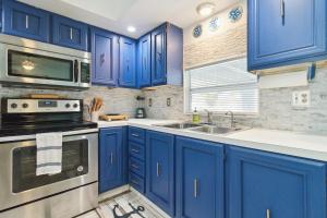 una cucina con mobili blu e un lavandino di Flamingo Bay Cottage cottage a Saint James City