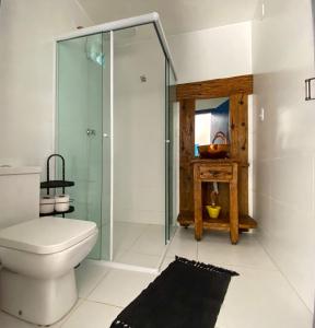 uma casa de banho com um WC e uma cabina de duche em vidro. em Villas & Residencial Três Marias à 300 mts do Centro Histórico Paraty em Paraty