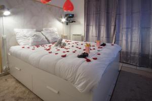 uma cama branca com rosas vermelhas e velas em Thermal & Home cinéma Disneyland Paris and Terrasse em Lagny