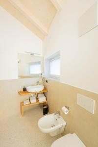a white bathroom with a sink and a toilet at Agriturismo Val Castel in Sporminore