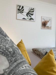 a living room with yellow pillows on a couch at Schwarzwaldliebe Ferienzimmer mit Bad in Gaggenau