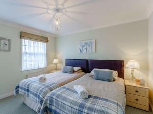 3 Bed in Broadstairs 47658 في برودستيرز: غرفة نوم بسريرين ونافذة