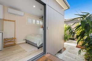 a bedroom with a bed and a sliding glass door at Tiny House Stays House 1 in Sanctuary Point