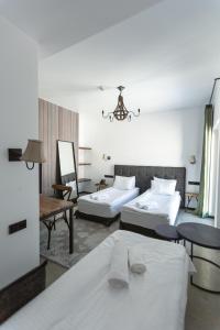 Habitación de hotel con 2 camas y mesa en Hotel Roshe Gudauri en Gudauri