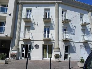 un gran edificio blanco con columnas y balcones en Hotel Ariston Imperial en Porto Garibaldi