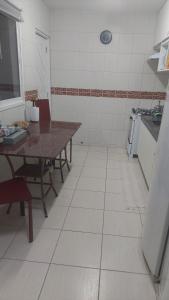 eine Küche mit einem Tisch und einer Tableasteryasteryasteryasteryasteryasteryasteryasteryastery in der Unterkunft OTIMA CASA BARRA S MIGUEL AL REVEILLON e JANEIRO 2024 MINIMO 05 DIARIAS in Barra de São Miguel