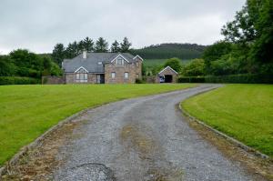 a gravel road leading to a large house at The Mountain Lodge Slievenamon spacious 4 bedroom house in Cloneen