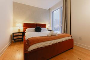 a bedroom with a large bed with a large window at Rozenhaus Hotel - Downtown Montreal in Montreal