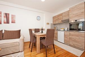 eine Küche und ein Esszimmer mit Tisch und Stühlen in der Unterkunft Kraljevi Cardaci in Kopaonik