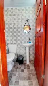 a bathroom with a toilet and a sink at Refúgio dos Lagos. in Cabo Frio