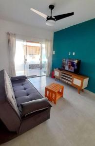ein Wohnzimmer mit einem Sofa und einem TV in der Unterkunft Refúgio dos Lagos. in Cabo Frio