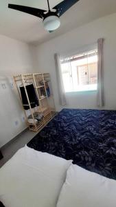 Schlafzimmer mit einem Bett und einem Deckenventilator in der Unterkunft Refúgio dos Lagos. in Cabo Frio