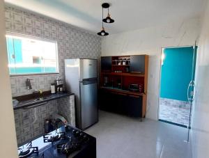 a kitchen with a refrigerator and a stove in it at Refúgio dos Lagos. in Cabo Frio