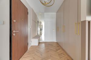 a hallway with white walls and a wooden floor at Nadmotławie Deluxe 1 Sauna & Siłownia by Grand Apartments in Gdańsk