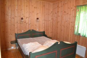 a bed in a room with a wooden wall at Mogard in Skjåk