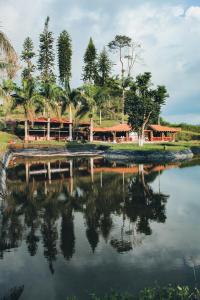 a resort with a reflection in a body of water at Cabaña Maribel encanto in Filandia
