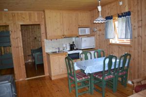 una cocina con mesa y sillas en una cabaña en Mogard, en Skjåk