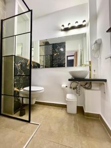 a bathroom with a sink and a toilet and a mirror at Metropole Apartments - Old City in Bucharest