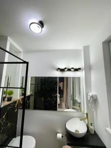 a bathroom with a toilet and a sink and a mirror at Metropole Apartments - Old City in Bucharest