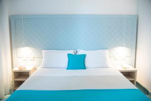 1 cama con cabecero azul y 2 mesitas de noche en Pietrablu Resort & Spa - CDSHotels, en Polignano a Mare