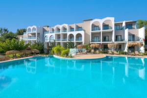 a large swimming pool in front of a building at Lindos Breeze Beach Hotel in Kiotari