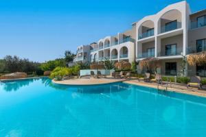 a large swimming pool in front of a building at Lindos Breeze Beach Hotel in Kiotari