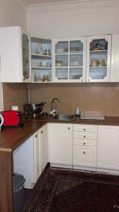 a kitchen with white cabinets and a sink at Apartment 70 m² drei Personen Prag kourimka 30 in Prague